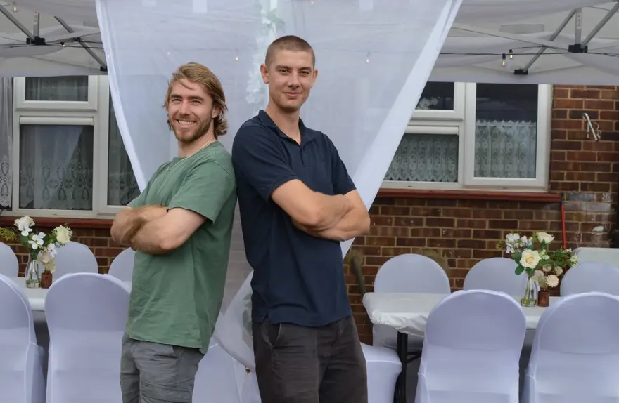 Dom and Henry in front of a completed garden party setup