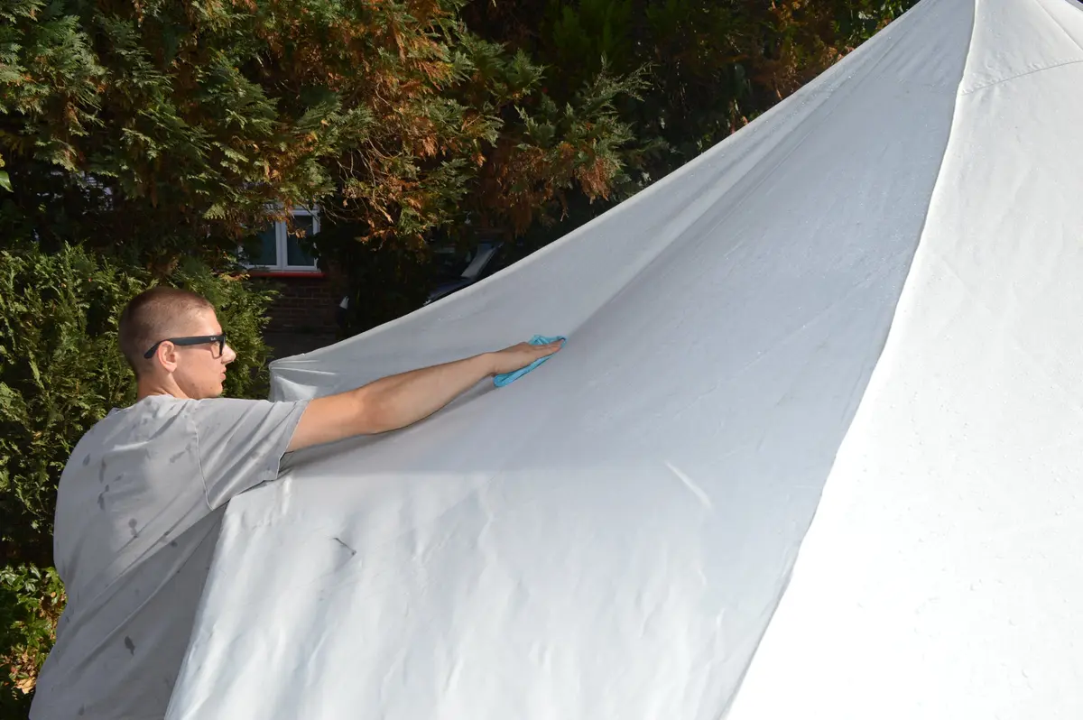 Henry cleaning a white gazebo canopy